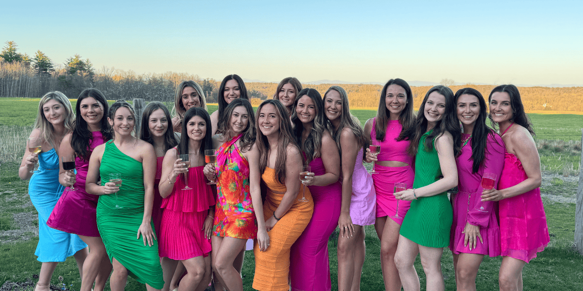 women in bright dress posing in front of a field at Galway rock