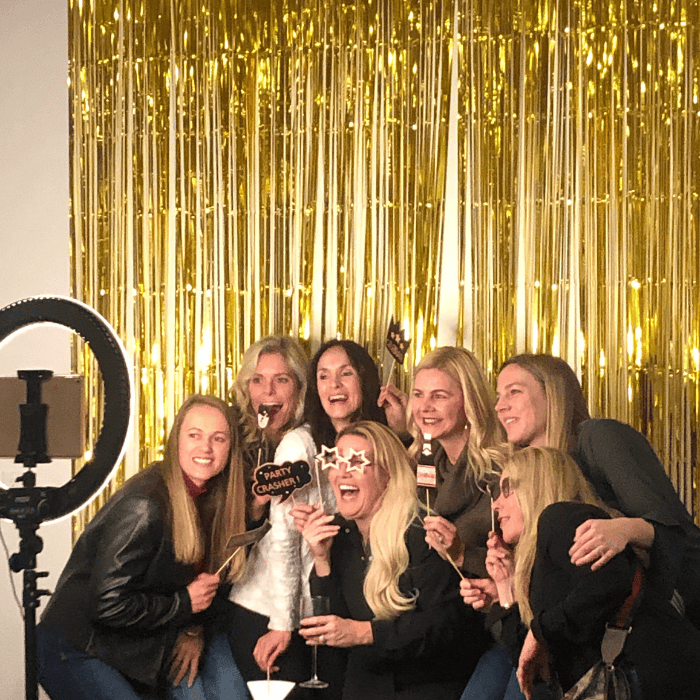 women laughing and taking a photo with the photo booth app at a private event